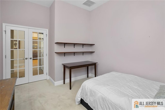 bedroom featuring light colored carpet and french doors