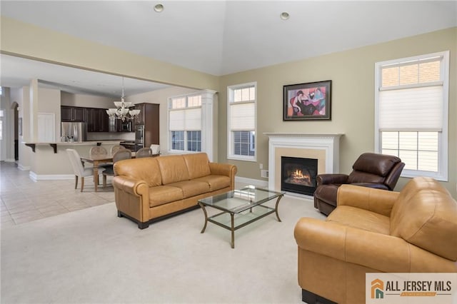 living room featuring light tile patterned floors, plenty of natural light, a chandelier, and vaulted ceiling