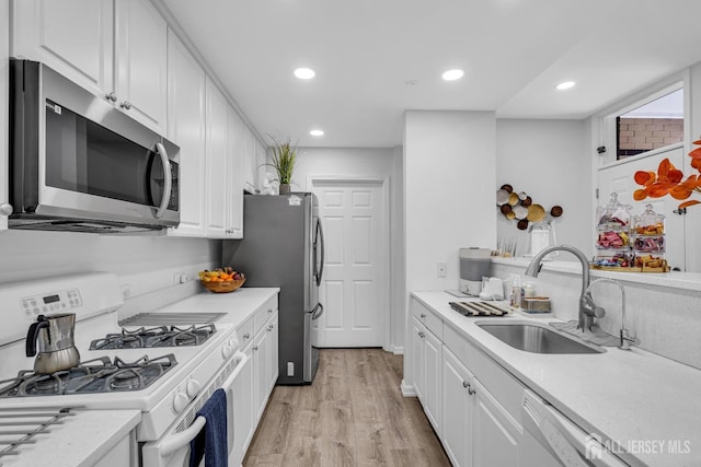358 Rector St Unit 218, Perth Amboy, NJ 08861 - kitchen with white cabinets, recessed lighting, light wood finished floors, a sink, and appliances with stainless steel finishes