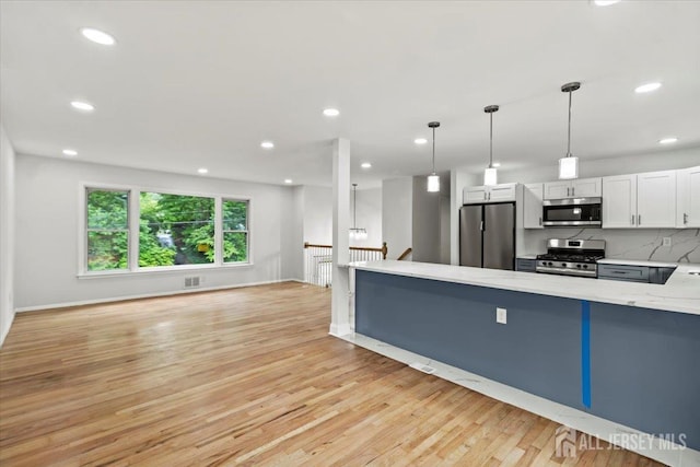 376 New Brunswick Ave, East Brunswick, NJ 08816 - kitchen featuring appliances with stainless steel finishes, light wood-style flooring, light stone countertops, tasteful backsplash, and white cabinets