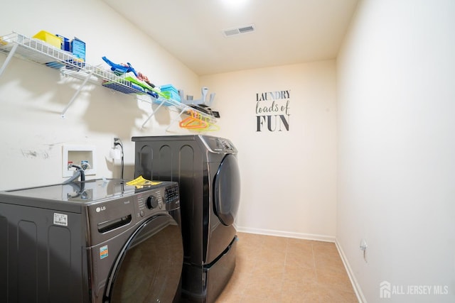 washroom featuring independent washer and dryer, tile patterned flooring, and baseboards
