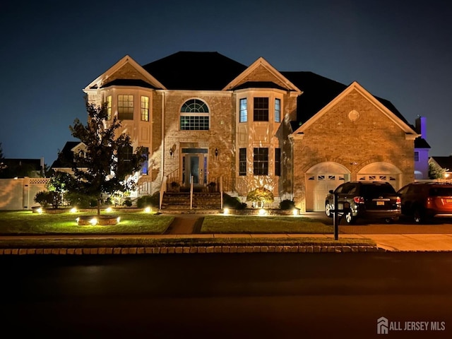 view of front of home with a lawn, an attached garage, french doors, driveway, and stone siding