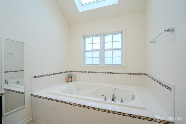bathroom with a skylight and a bath
