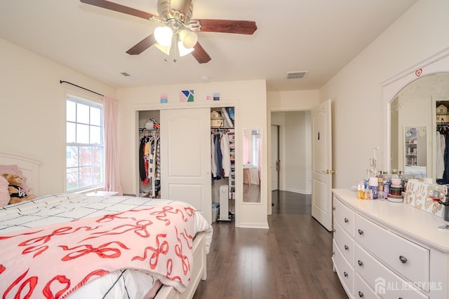 bedroom featuring dark wood-style flooring, a closet, and a ceiling fan