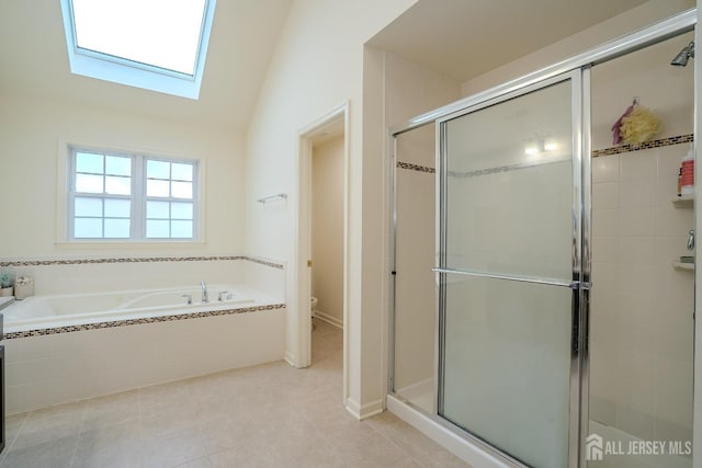 bathroom featuring a stall shower, toilet, a bath, a skylight, and vaulted ceiling
