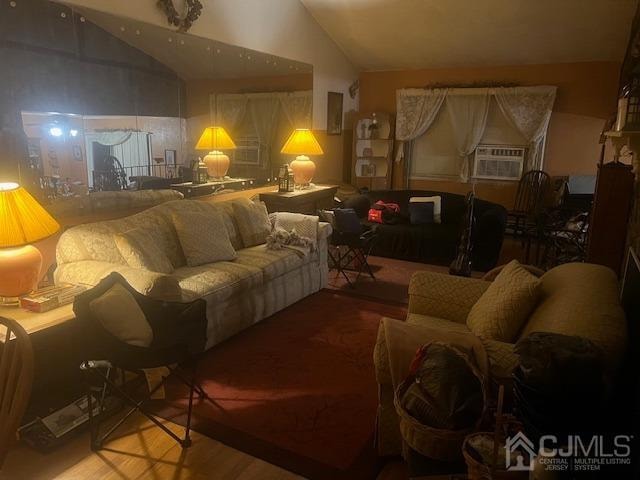 living room with cooling unit, lofted ceiling, and hardwood / wood-style floors