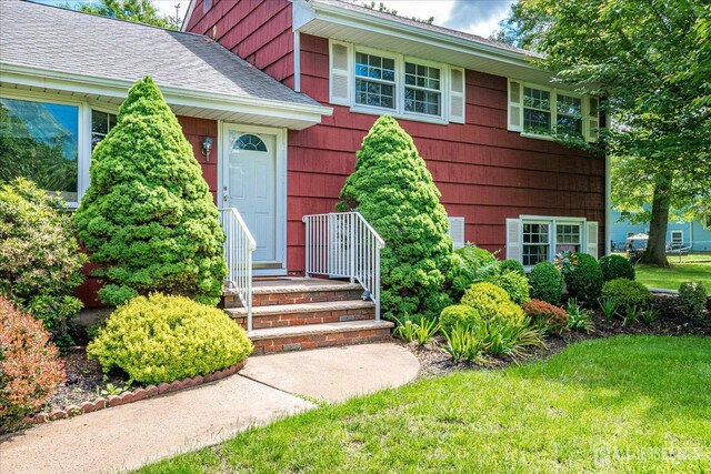 200 Elwood St, Piscataway, NJ 08854 - doorway to property featuring roof with shingles and a lawn