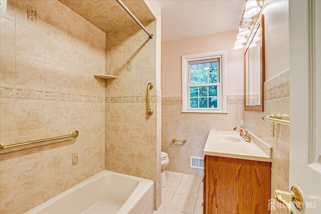 200 Elwood St, Piscataway, NJ 08854 - full bathroom with tile patterned flooring, toilet, vanity, shower / bath combination, and tile walls