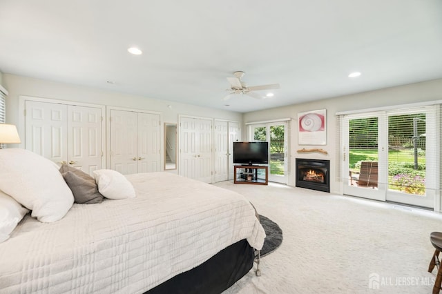 2 Derby Ln, East Brunswick, NJ 08816 - bedroom with two closets, light colored carpet, a warm lit fireplace, recessed lighting, and a ceiling fan