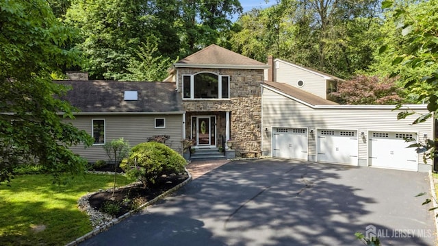 2 Derby Ln, East Brunswick, NJ 08816 - traditional home featuring driveway, an attached garage, stone siding, a front yard, and a chimney