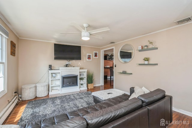 16 Taft Ave, Edison, NJ 08817 - living area with a baseboard heating unit, a ceiling fan, wood finished floors, ornamental molding, and a glass covered fireplace