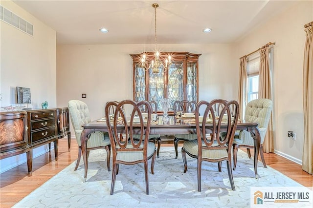 dining space with a notable chandelier, recessed lighting, visible vents, light wood-style flooring, and baseboards