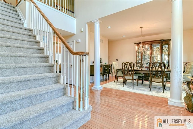 2 Kristen Ct, Franklin, NJ 08873 - stairway featuring ornate columns, wood-type flooring, a chandelier, a high ceiling, and recessed lighting