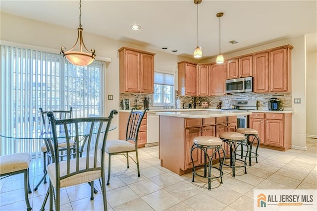 kitchen featuring stainless steel appliances, decorative backsplash, light countertops, and pendant lighting