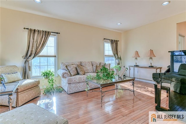 living area featuring recessed lighting, baseboards, and light wood finished floors