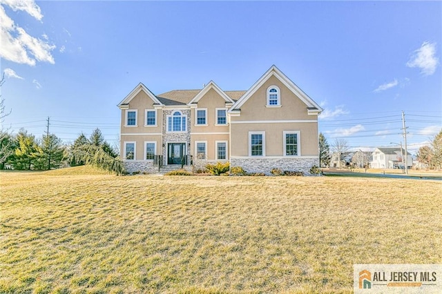 view of front of property featuring stone siding, a front lawn, and stucco siding