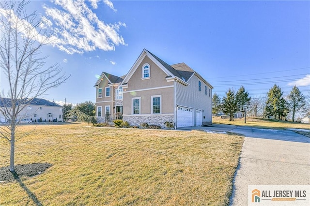 view of front of house featuring a garage, stone siding, a front lawn, and stucco siding