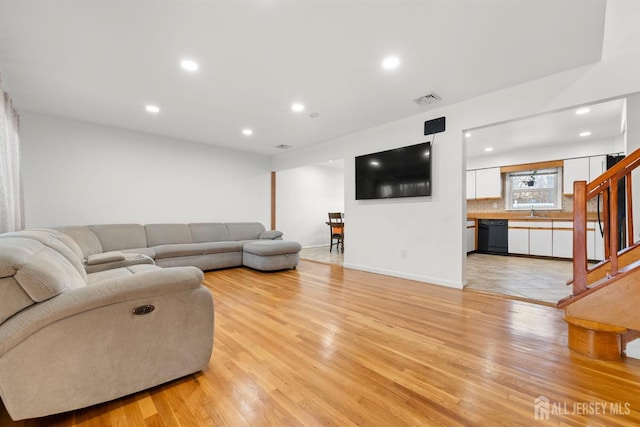 living room with sink and light hardwood / wood-style flooring