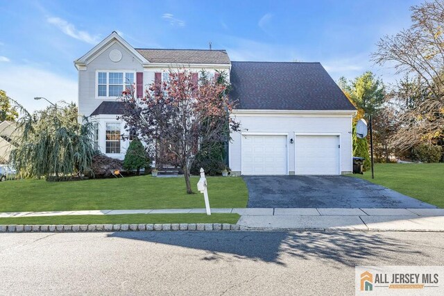 view of property featuring a front yard and a garage