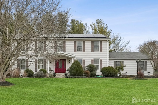 colonial inspired home with solar panels and a front lawn