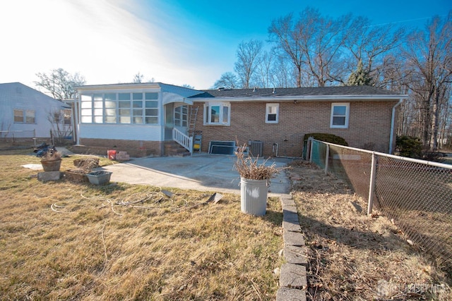 rear view of house featuring entry steps, a patio, fence, cooling unit, and brick siding