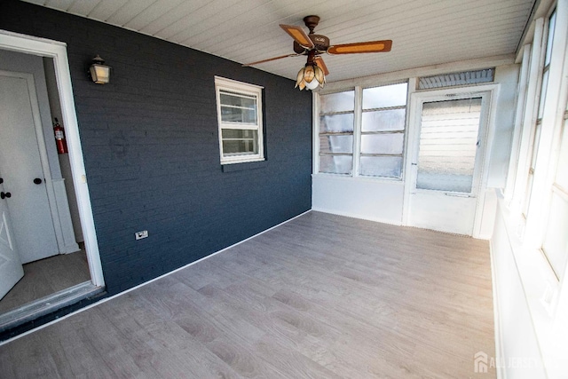 unfurnished sunroom with a ceiling fan