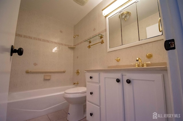 full bath with vanity, shower / tub combination, tile patterned flooring, tile walls, and toilet