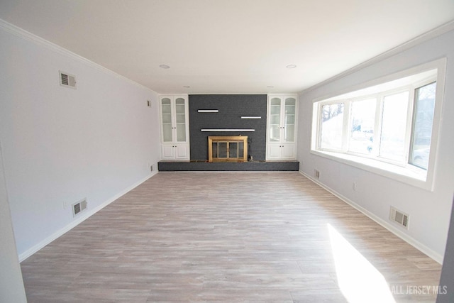 unfurnished living room with visible vents, a fireplace, and crown molding