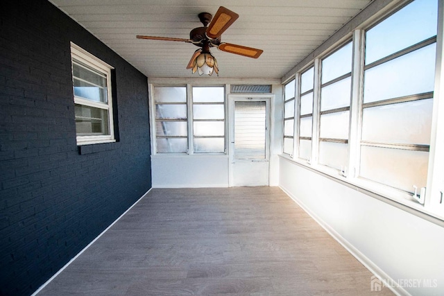 unfurnished sunroom with a ceiling fan