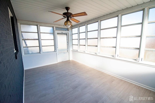 unfurnished sunroom featuring a ceiling fan