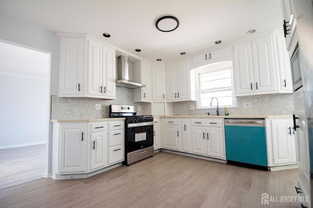 kitchen with dishwashing machine, gas range, light countertops, and wall chimney exhaust hood