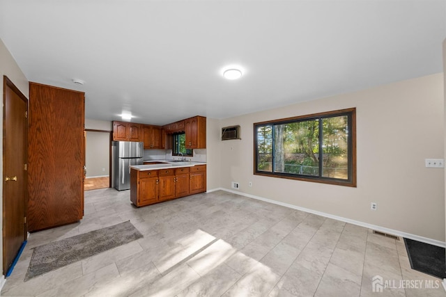 39 Miara St, Sayreville, NJ 08859 - kitchen with freestanding refrigerator, light countertops, brown cabinetry, a peninsula, and open floor plan
