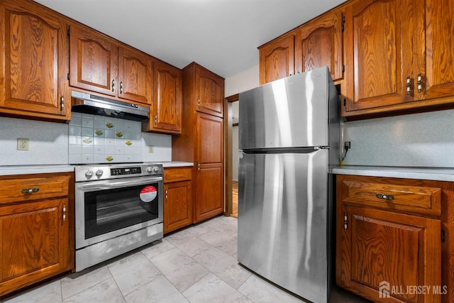 39 Miara St, Sayreville, NJ 08859 - kitchen with stainless steel appliances, under cabinet range hood, light countertops, brown cabinets, and tasteful backsplash