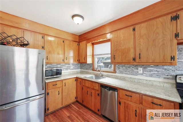 49 Paul St, Fords, NJ 08863 - kitchen featuring appliances with stainless steel finishes, light countertops, decorative backsplash, and wood finished floors
