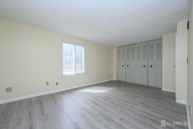 unfurnished bedroom with baseboards and wood finished floors