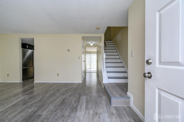 entrance foyer featuring baseboards, wood finished floors, and stairway