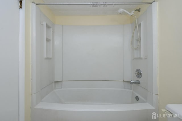 bathroom with bathtub / shower combination and toilet
