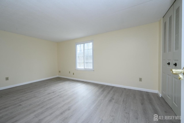 unfurnished room with baseboards and wood finished floors