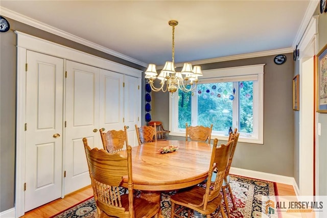 dining room featuring light wood-type flooring, an inviting chandelier, and ornamental molding