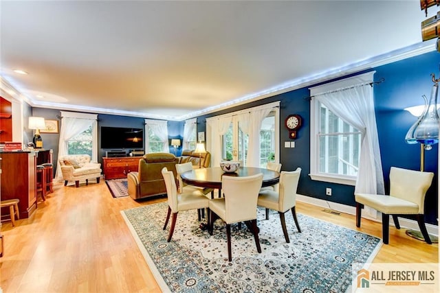 dining space featuring hardwood / wood-style floors, a healthy amount of sunlight, and ornamental molding