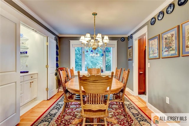 dining area featuring light hardwood / wood-style floors, crown molding, and a notable chandelier