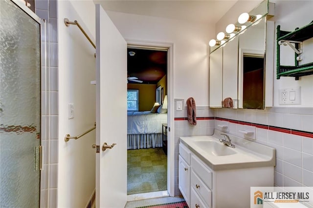 bathroom featuring vanity, tile walls, and a shower with shower door