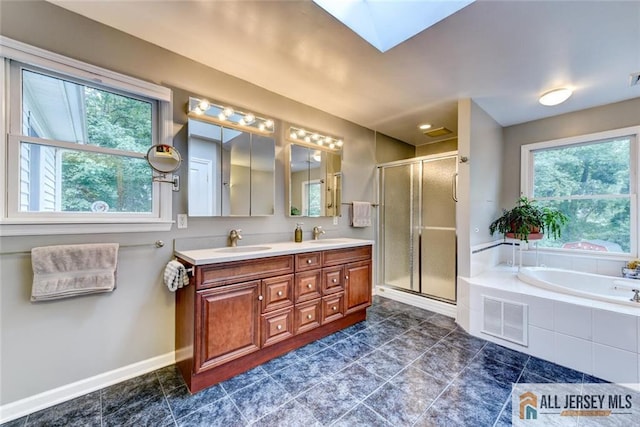 bathroom featuring a skylight, a wealth of natural light, vanity, and shower with separate bathtub