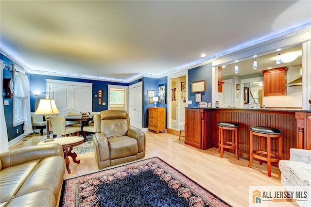 living room with ornamental molding and light wood-type flooring