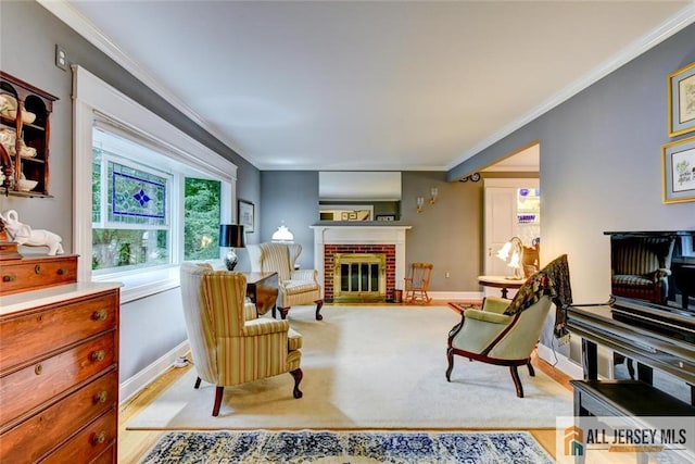 living area with crown molding, a fireplace, and light wood-type flooring