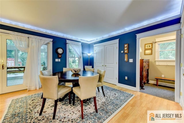 dining area featuring hardwood / wood-style floors, a wealth of natural light, and crown molding