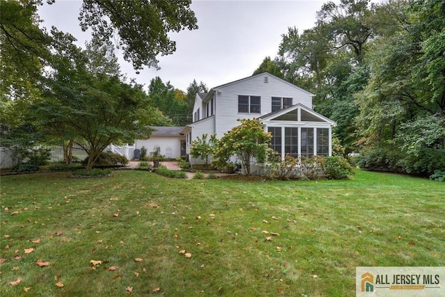 back of property with a lawn and a sunroom