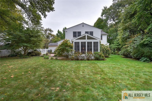 back of house with a lawn and a sunroom