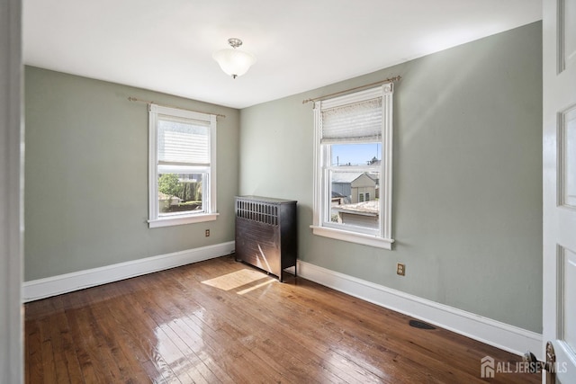 22 Booream Ave, Milltown, NJ 08850 - empty room featuring heating unit, hardwood / wood-style flooring, and a wealth of natural light