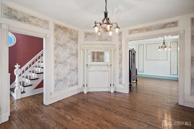 22 Booream Ave, Milltown, NJ 08850 - unfurnished dining area featuring an inviting chandelier, a wood stove, dark wood-style flooring, and stairs